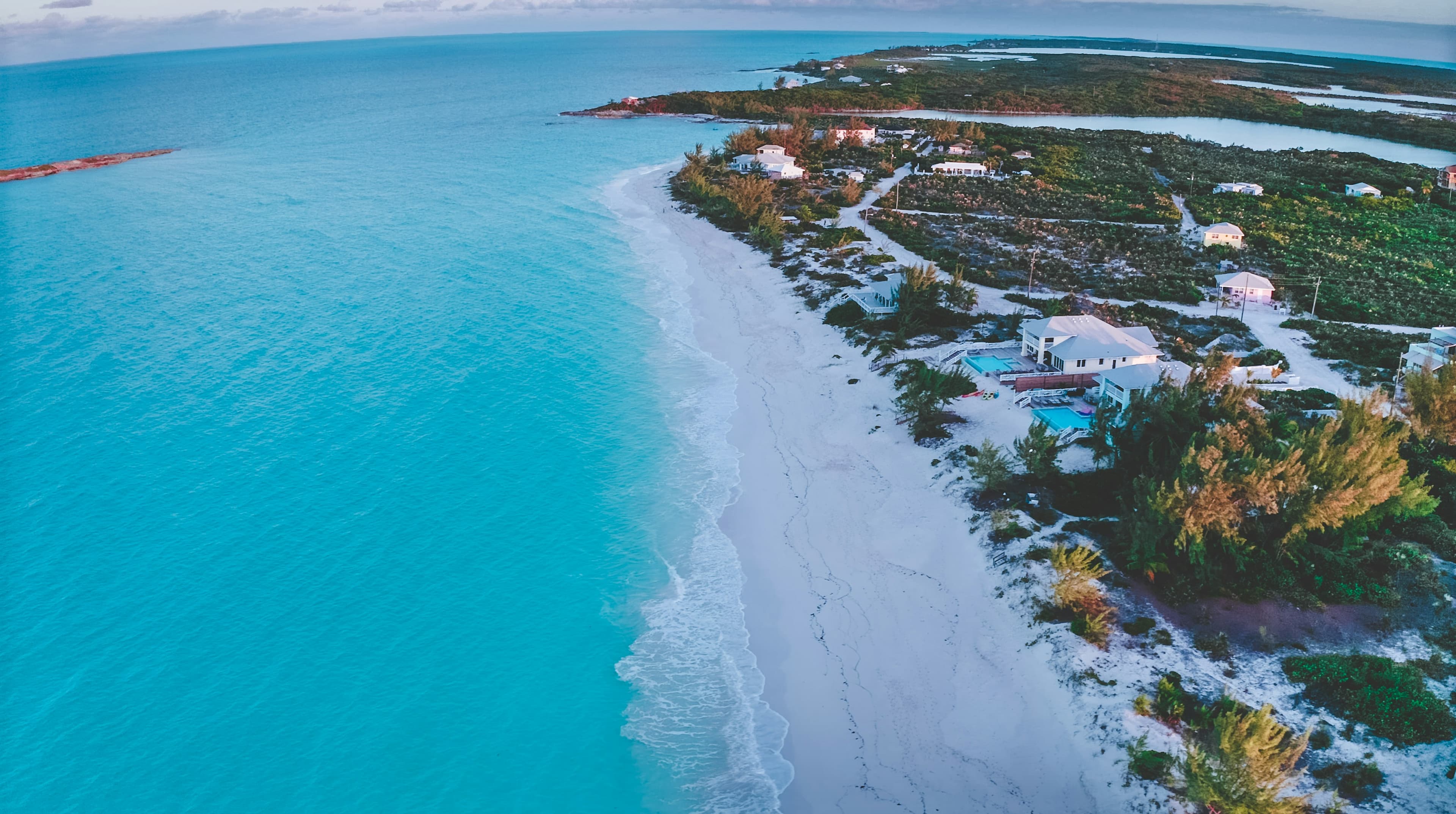 Aerial view of a white sand shoreline and turquoise water in the Bahamas