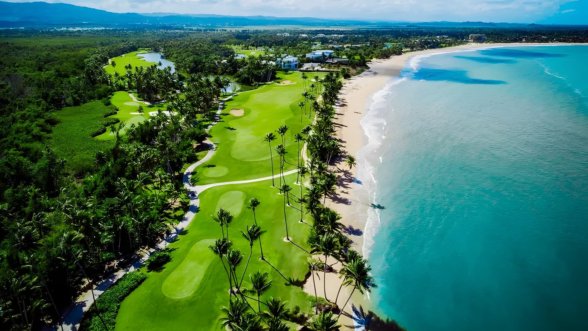 Aerial view of the golf course meeting the beach at Bahía Beach